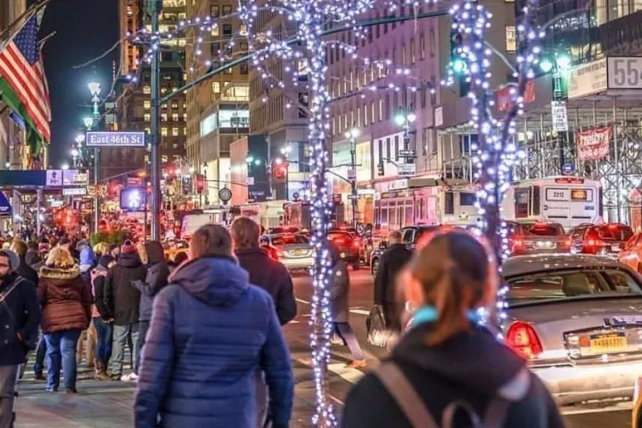a group of people walking down a busy city street